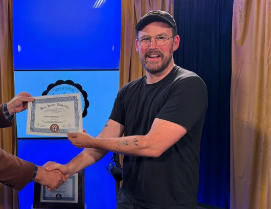 Zach Cregger segurando um diploma
