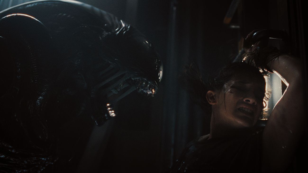 Um xenomorfo se prepara para matar uma vítima humana aterrorizada em Alien: Romulus.
