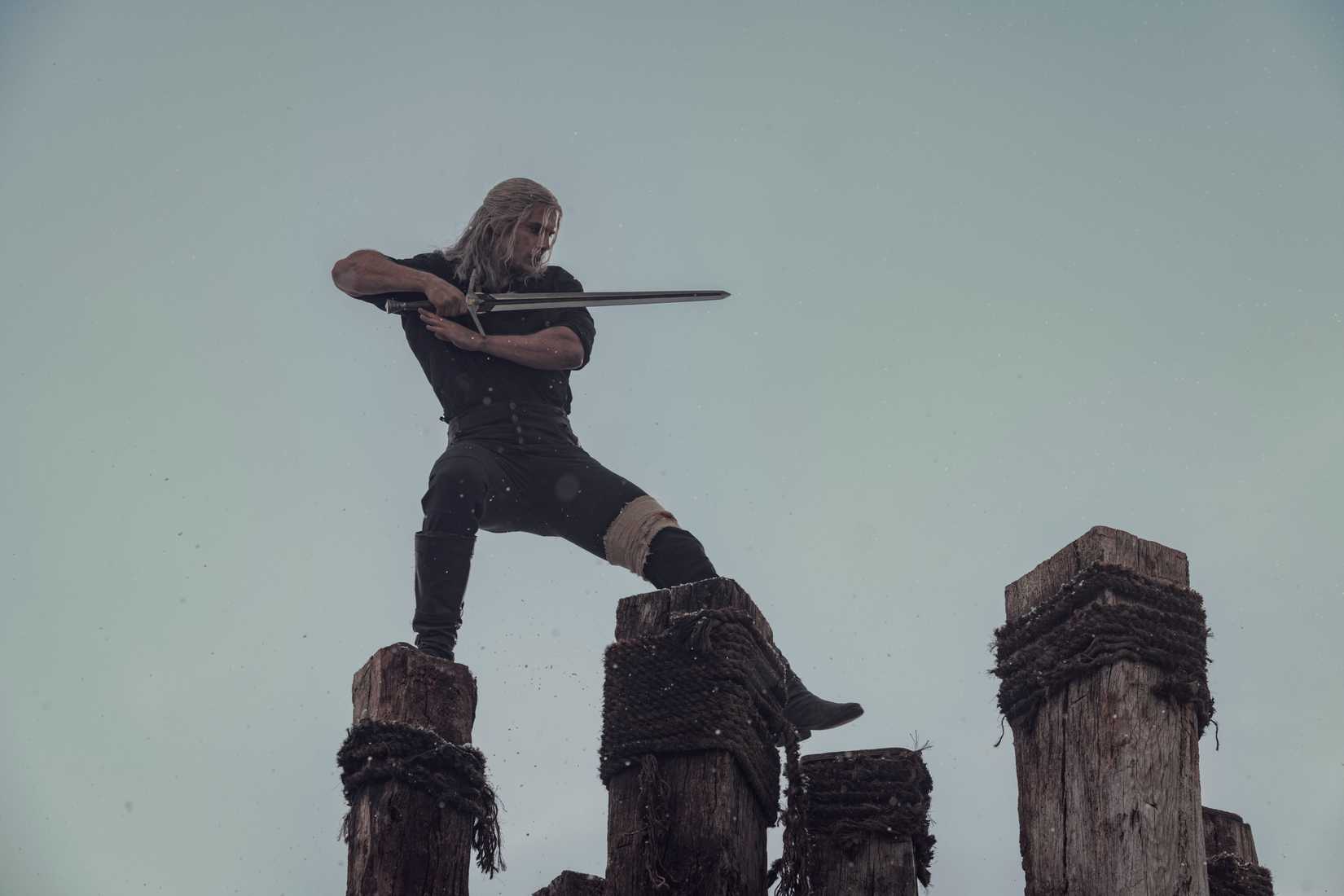 Geralt está no topo de alguns pilares com sua espada no Ready in Netflix, The Witcher