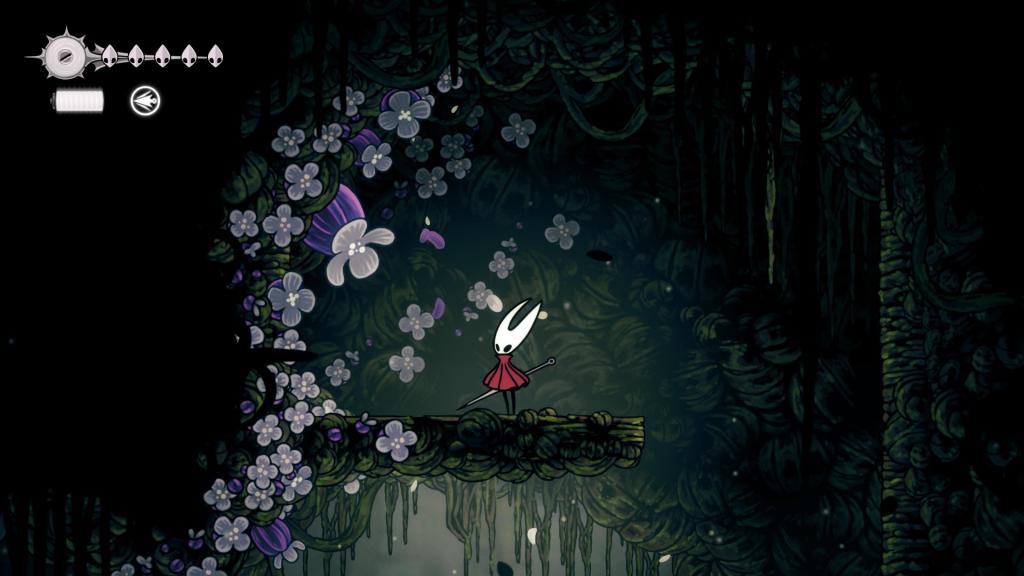 Hornet parado ao lado de uma localização do Heart Polliss no início de Shellwood em Silksong.