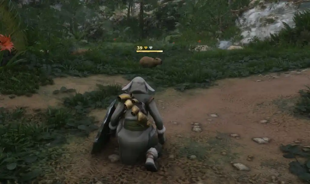 Uma captura de tela de Enshrouded mostrando o personagem do jogador agachado para domar uma capivara à sua frente. A capivara tem uma barra de saúde amarela e um dos dois corações amarelos acima dela.