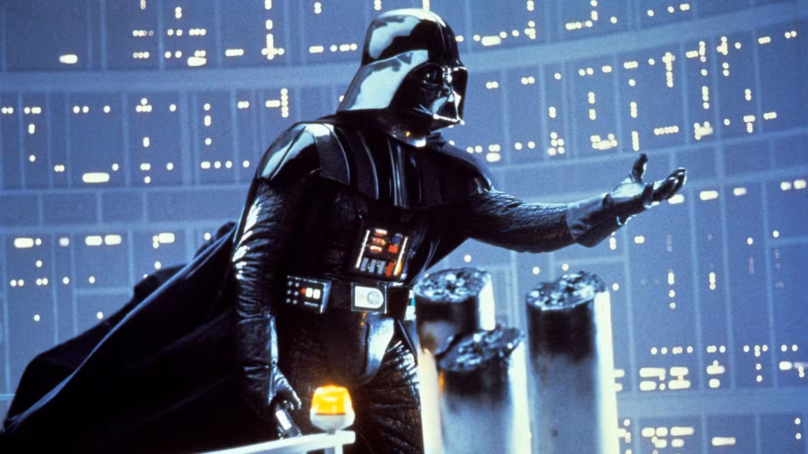 Darth Vader estende a mão enquanto está cercado por uma sala escura, de ficção científica e futurística em O Império Contra-Ataca