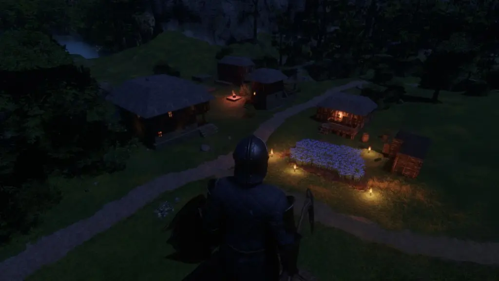 Uma vila construída por jogadores à noite em Enshrouded.