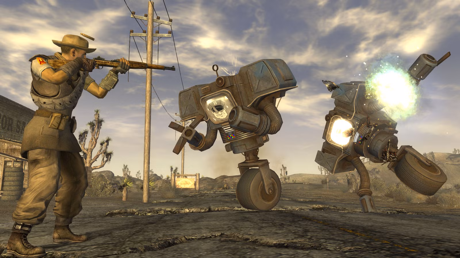 Um jogador em Fallout: New Vegas confronta dois autômatos de segurança, robôs volumosos com mãos ávidas que se equilibram em uma roda, com um rifle.
