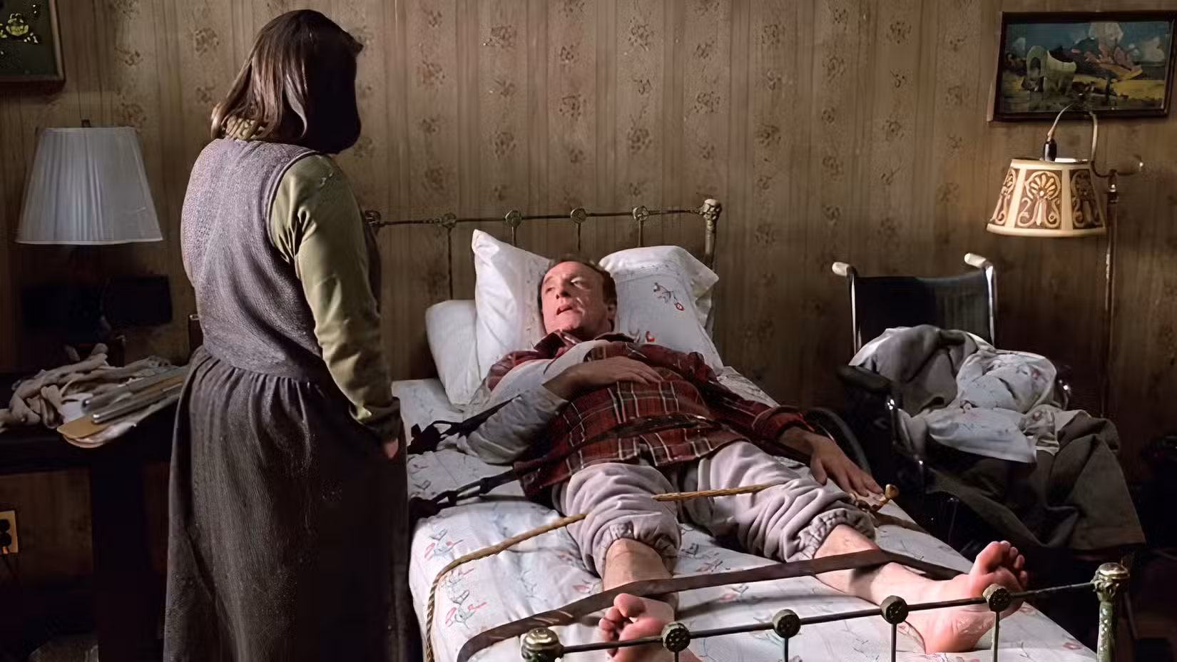 Paul está amarrado a uma cama na casa de Annie, incapaz de se mover.