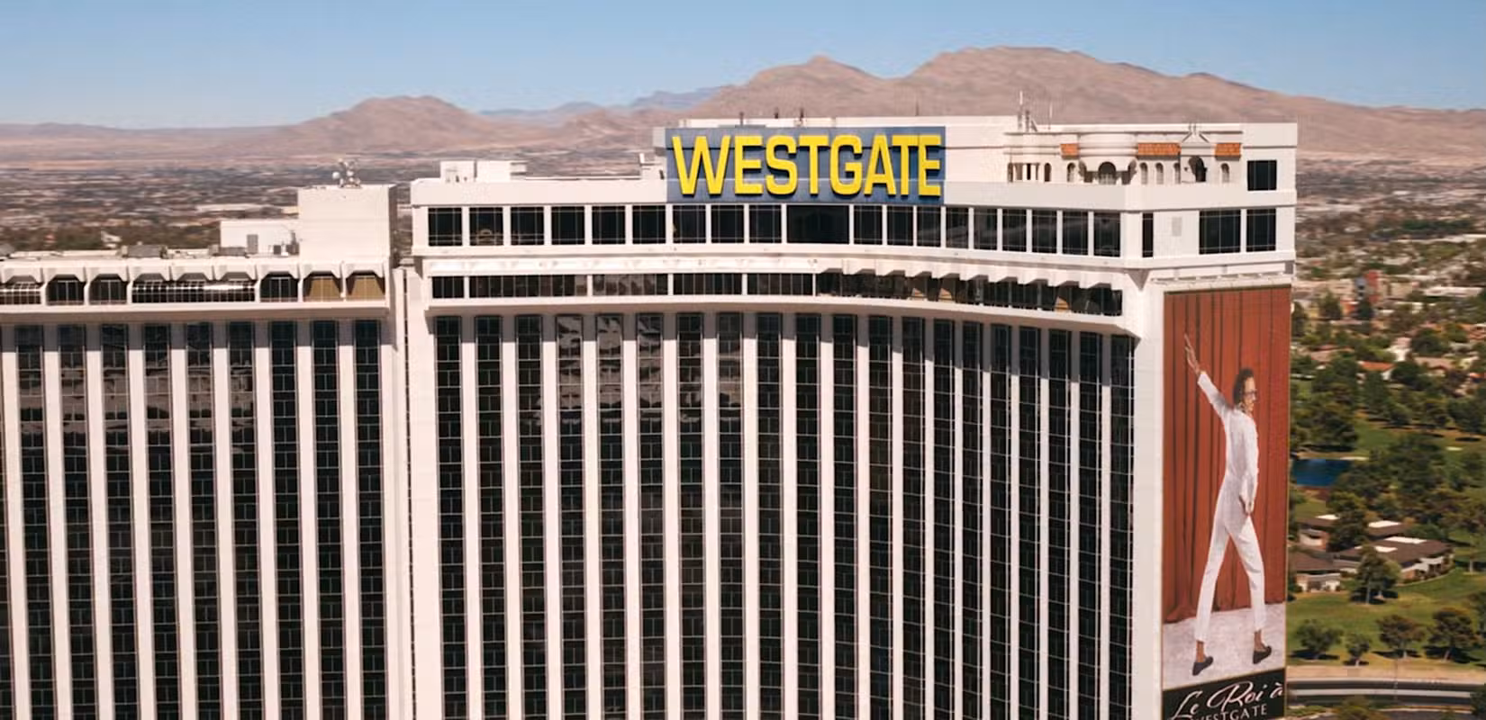 Uma foto do resort e cassino Westgate em Las Vegas, com um pôster gigante de Koumba Diabaté (Samba Schutte) de branco, fazendo uma pose ao estilo de Elvis, no episódio 6 de Pluribus