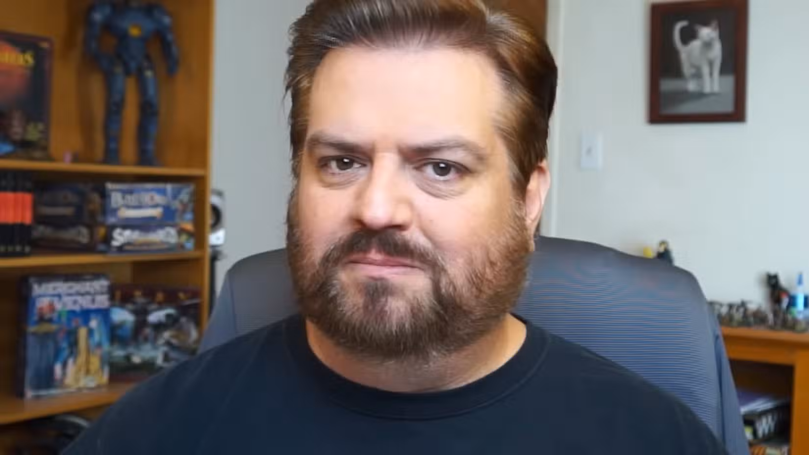 Um homem com barba olhando diretamente para a câmera