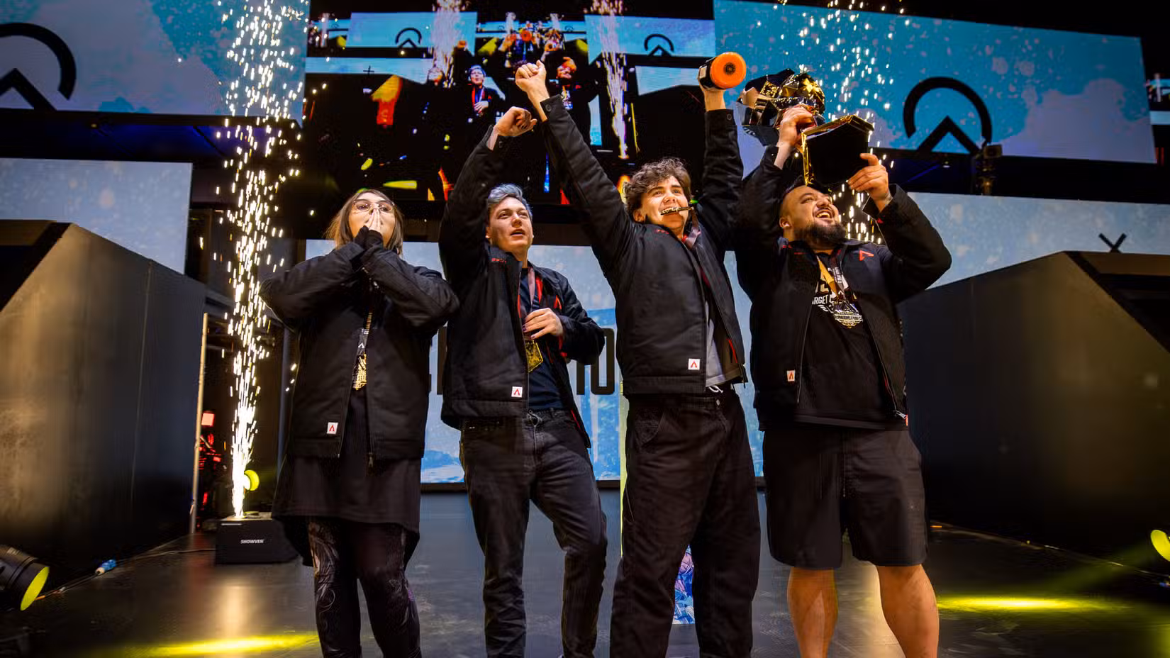 A Equipe Oblivion segura o troféu do Campeonato ALGS enquanto faíscas pirotécnicas voam atrás deles.