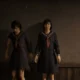 Os dois eus de Hinako encostados em uma parede