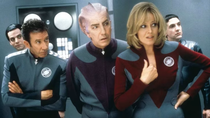 Tim Allen, Alan Rickman e Sigourney Weaver vestindo uniformes estilo Star Fleet em Galaxy Quest.