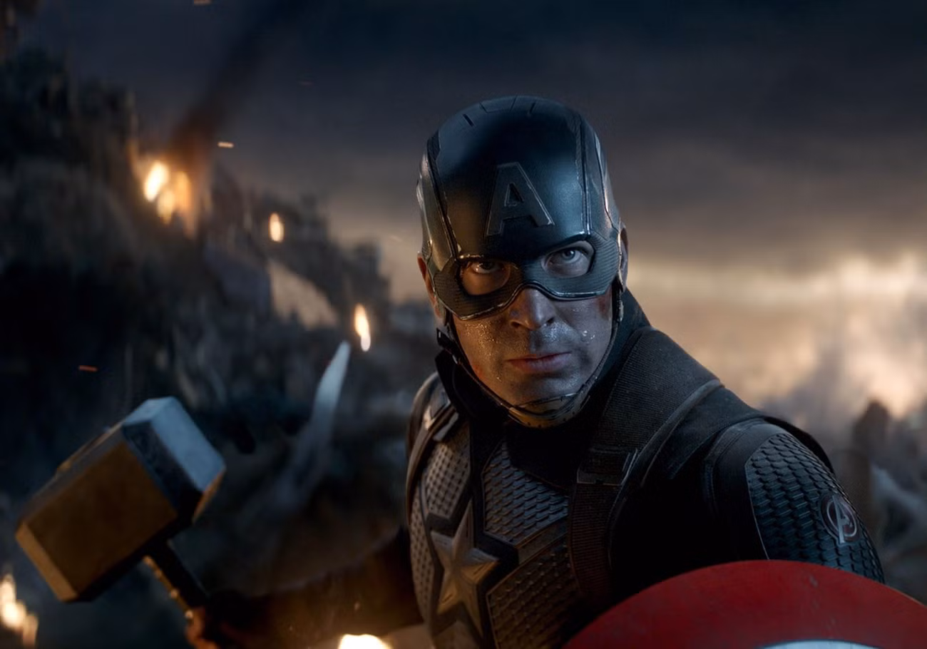 Capitão América segura seu escudo e o martelo de Thor em uma caixa do tamanho IMAX de Vingadores: Ultimato