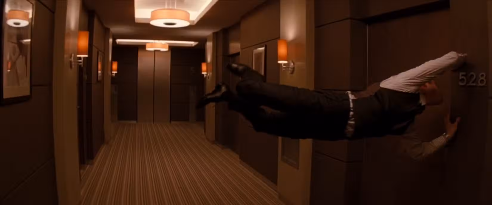 Joseph Gordon-Levitt flutua por um corredor que teve sua gravidade alterada em uma cena de sonho de Inception, de Christopher Nolan 