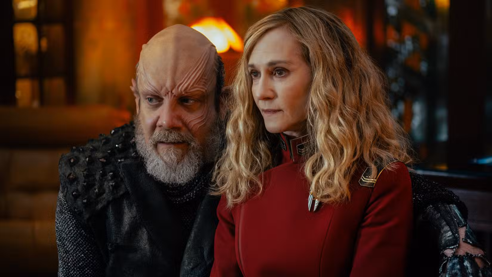 O pirata espacial Nus Braka (Paul Giamatti) está com o braço em volta da capitã Nahla Ake (Holly Hunter), que não está feliz com isso na Academia da Frota Estelar