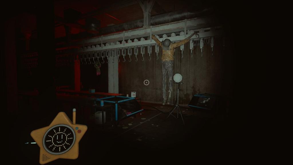 Um corpo pendurado em ganchos de carne na escura sala Poppy Playtime