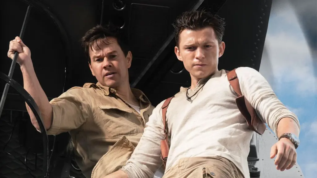 Mark Walhberg (esquerda) e Tom Holland (direita) como Sully e Nate olhando para baixo do avião no filme Uncharted