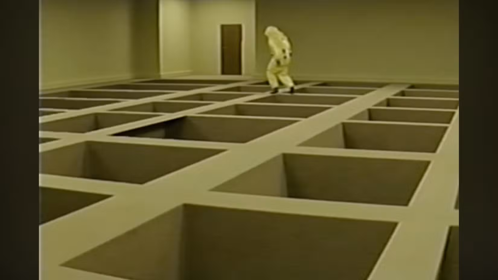 Um funcionário da Backrooms em um traje anti-risco navega cuidadosamente por uma sala estranha com enormes buracos quadrados no chão.