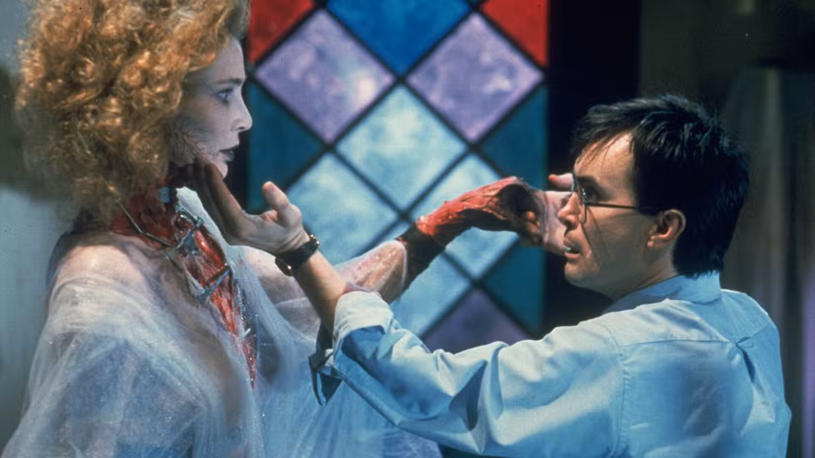 O Herbert West de óculos segura suavemente o queixo de uma mulher reanimada (A Noiva) em Bride of Re-Animator