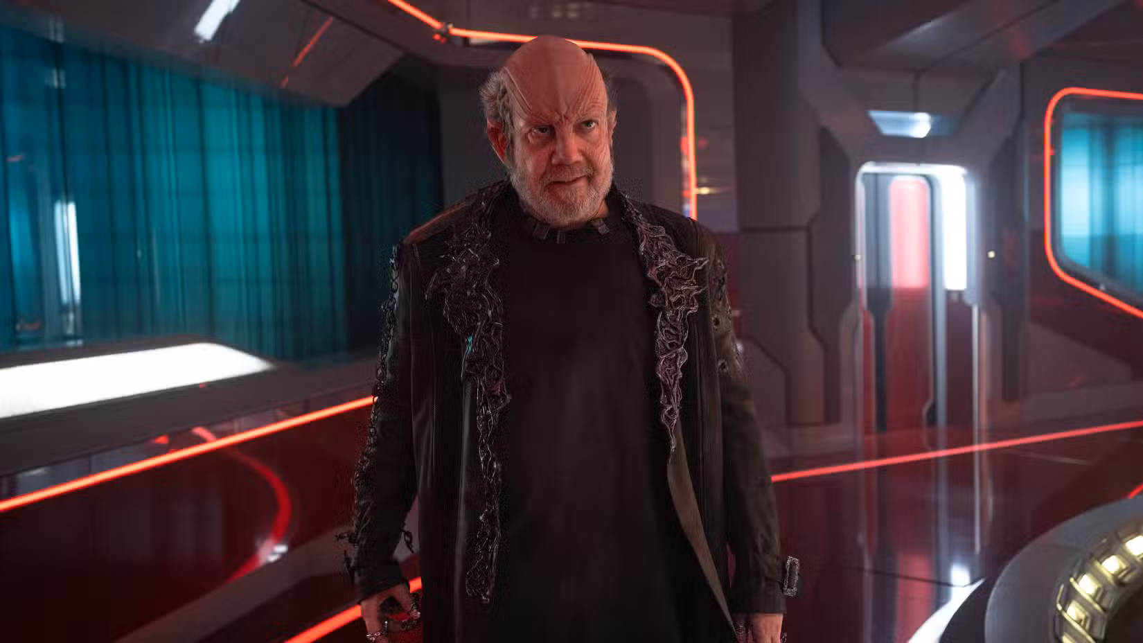 Nus Braka (Paul Giamatti) está em um corredor do USS Athena na Academia da Frota Estelar