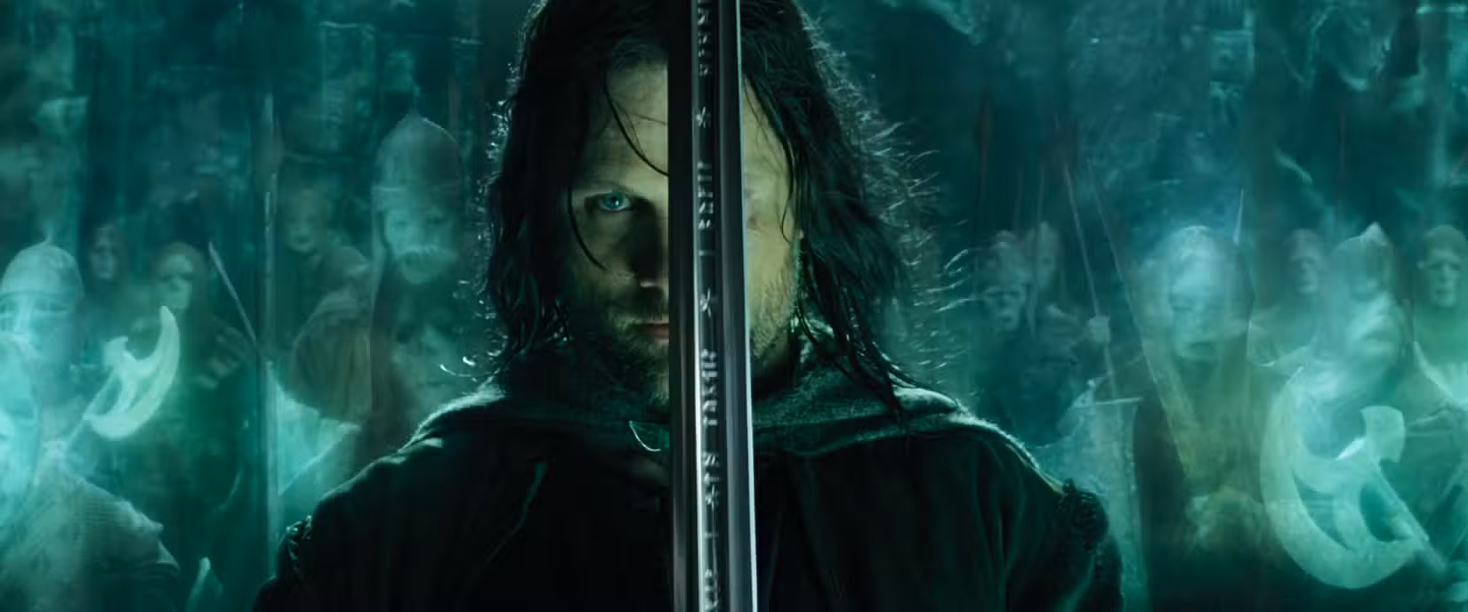 Aragorn segura sua espada no alto com os espíritos dos guerreiros atrás dele em uma foto de O Senhor dos Anéis: O Retorno do Rei