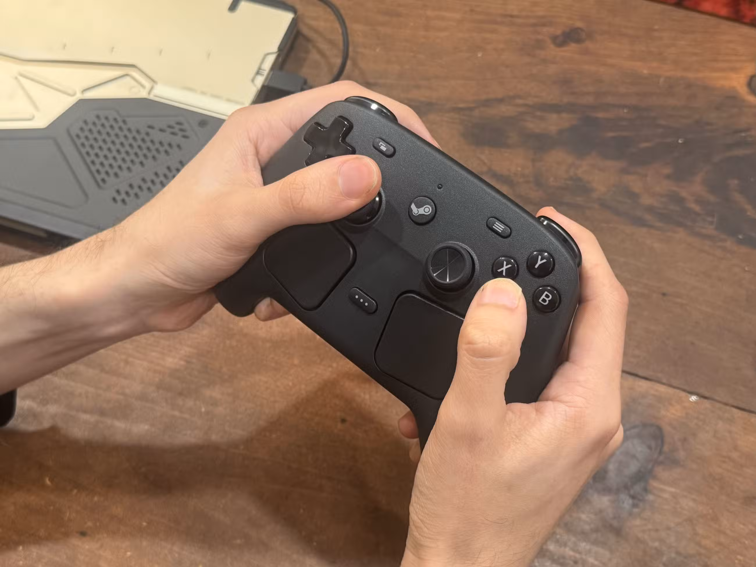 As mãos seguram um controlador Steam.