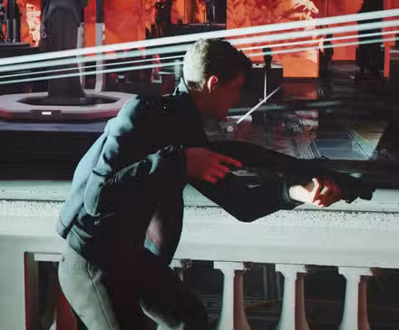James Bond segura uma espingarda em uma sala iluminada em vermelho enquanto balas passam
