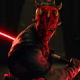 Uma imagem de Star Wars: Maul – Shadow Lord. Ele retrata Darth Maul, um alienígena de pele vermelha, manchas escuras e um sabre de luz vermelho dupla face, olhando ferozmente.