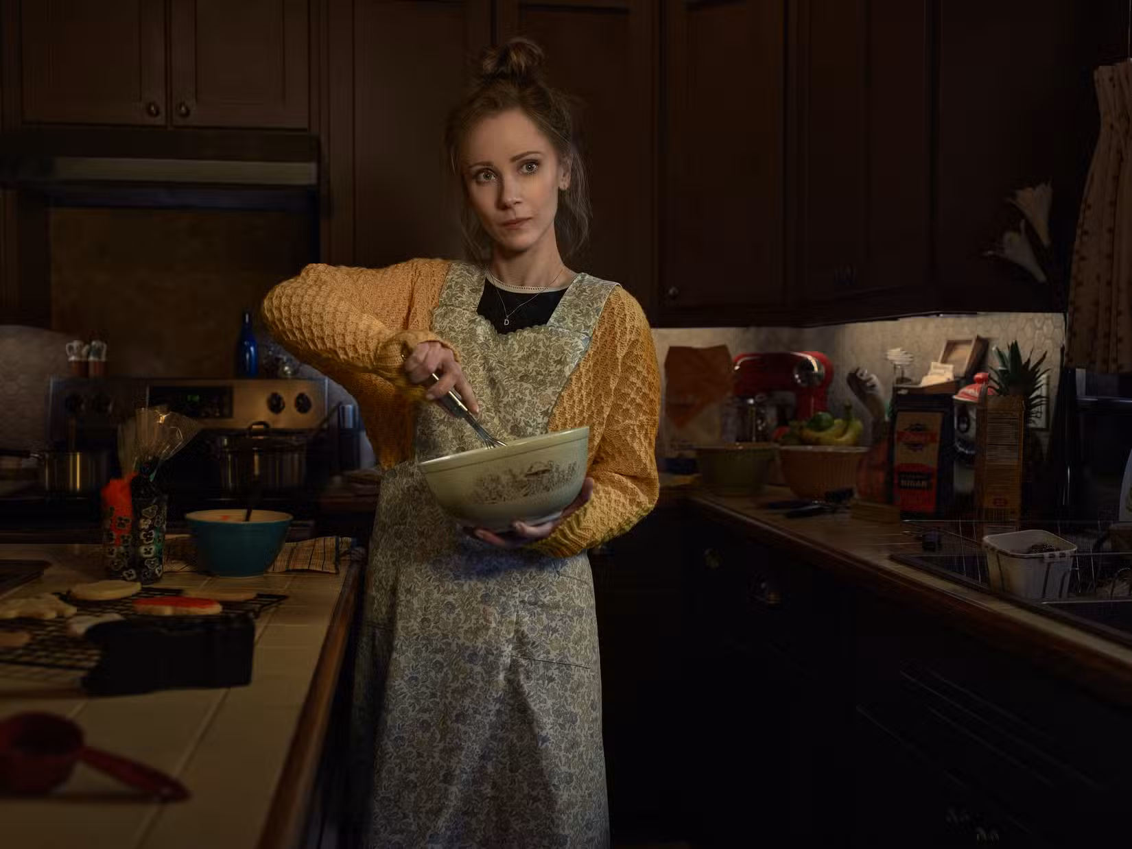 Juno Temple como Dot Lyon está de avental com uma tigela nas mãos na 5ª temporada de Fargo
