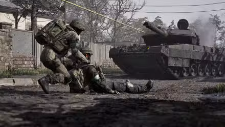 A soldier in Wardogs dragging a fallen ally across the road as a tank advances toward them.