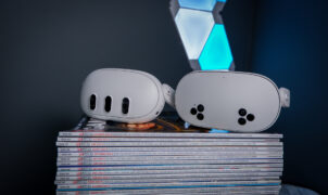 A Meta Quest 3S, alongside a Quest 3 and Quest 2, on a stack of PC Gamer magazine.