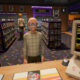 A 1990s video rental store with someone waiting at the counter
