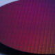 A close-up stylized photo of a silicon wafer, showing many small processor dies